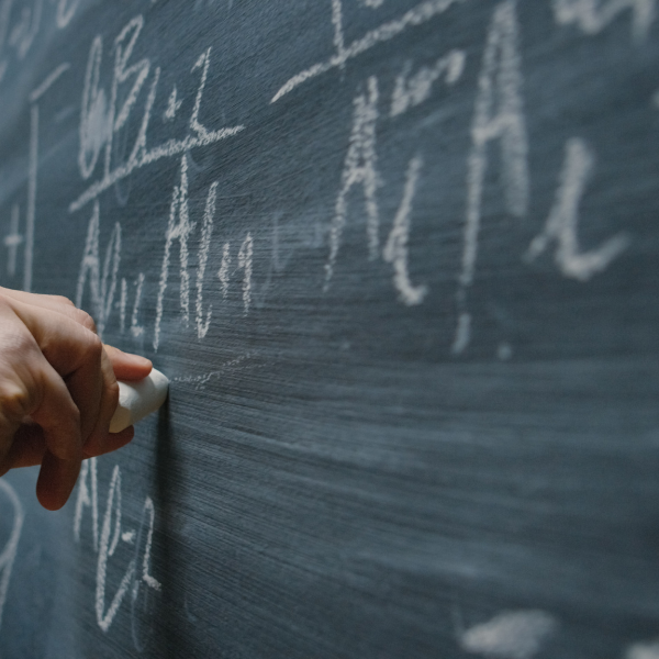 A person writes on a chalkboard