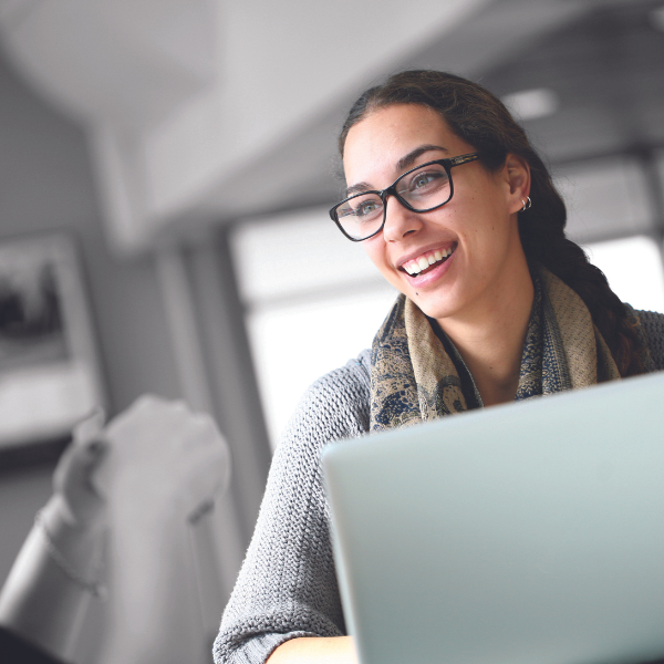 Woman looks to someone while on her laptop