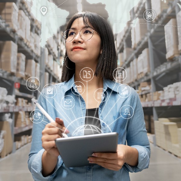 A woman in a warehouse surrounded by floating icons.