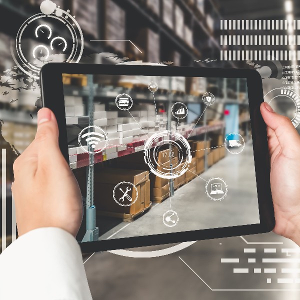 A person holding a tablet in a warehouse, with floating icons.