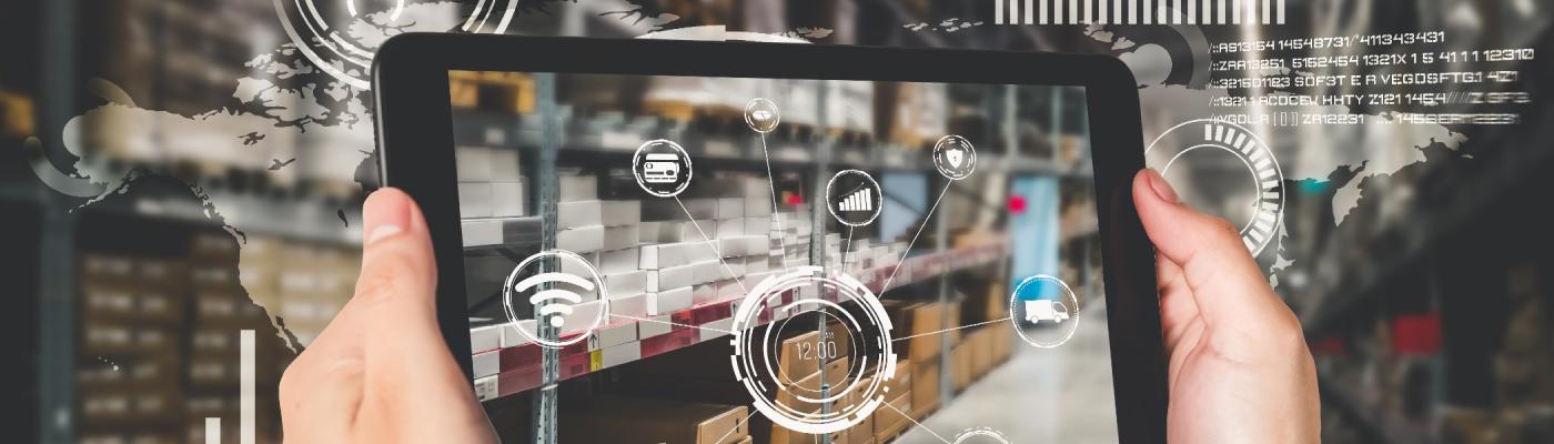 A person holding a tablet in a warehouse with floating icons