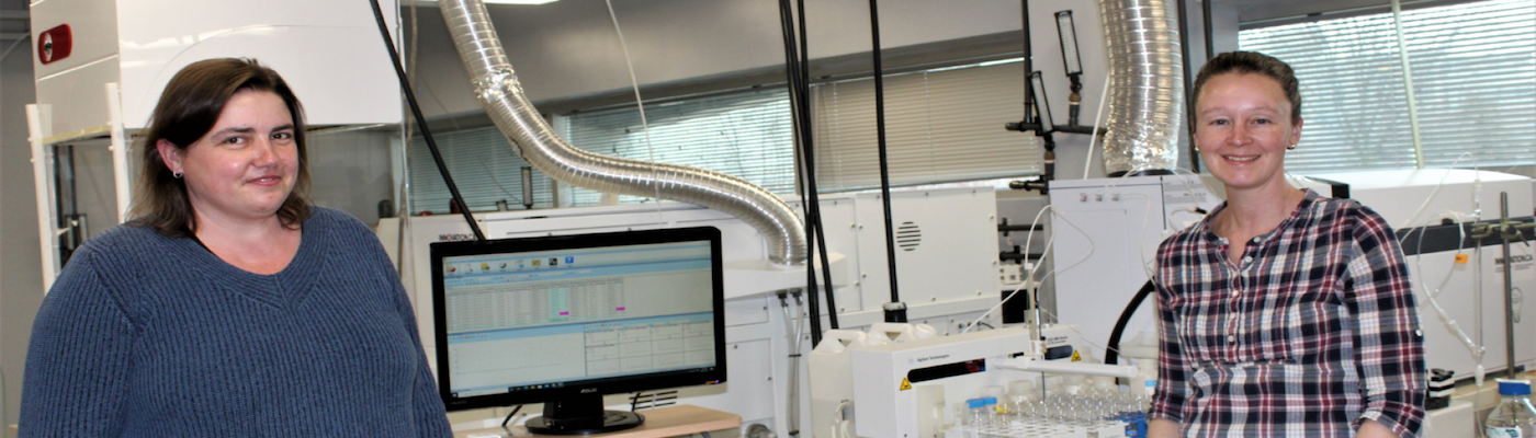 instructors Karla Neuman and Naomi Stock in front of instrument in Water Quality Centre