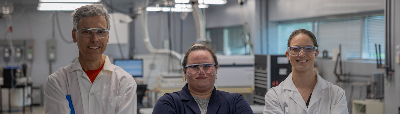 3 instructors standing, smiling, in water quality center (lab)