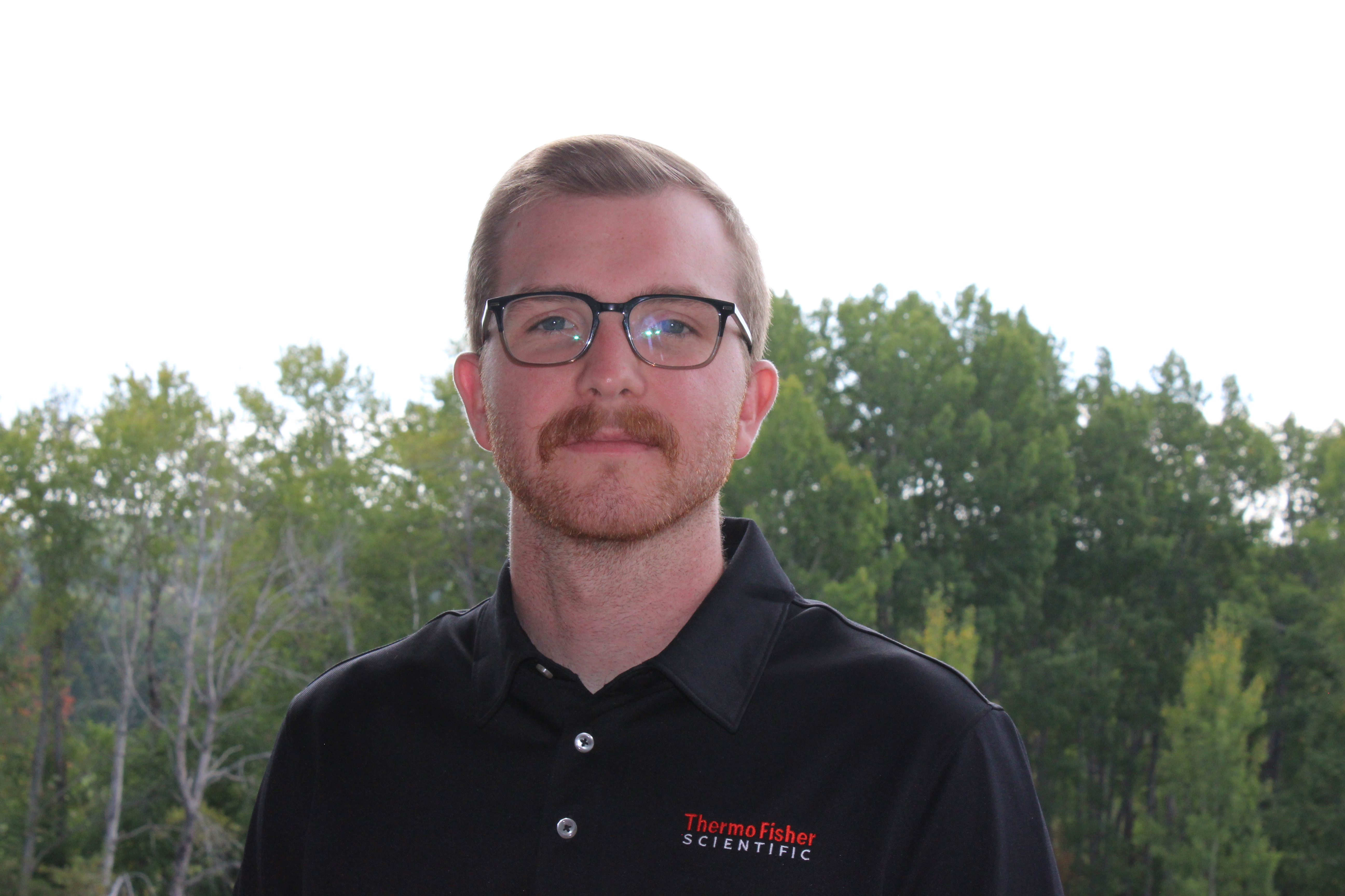 male grad student, mitchell lausen, smiling wearing thermo fisher scientific shirt