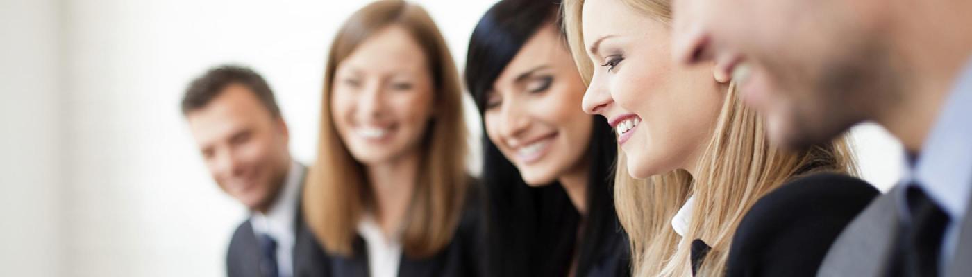 photo of people sitting on one side of boardroom table