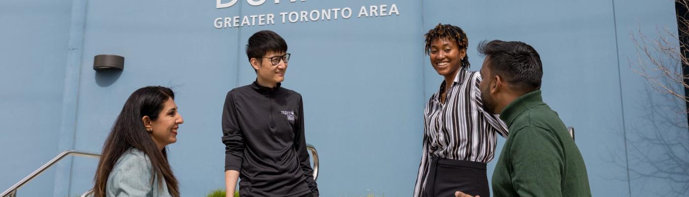 A group of students have a conversation outside the Durham GTA campus.