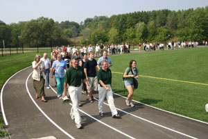 Trent President Bonnie Patterson and Bill Byrick, director of Athletics lead a group of students, staff and faculty around the new track at the opening ceremonies for the new field.