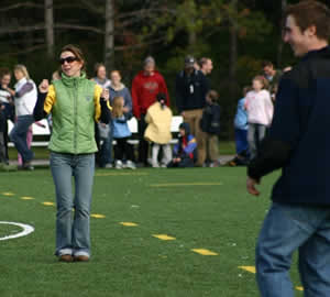 Trent students and their school children penpals do the Hokey Pokey on the athletics field