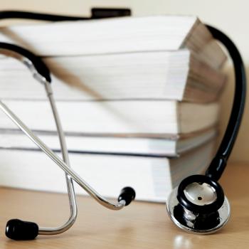 tack of textbooks with a stethoscope draped over them