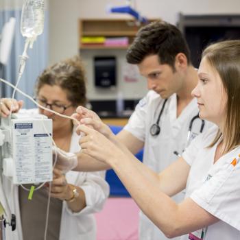 two students using an IV machine.