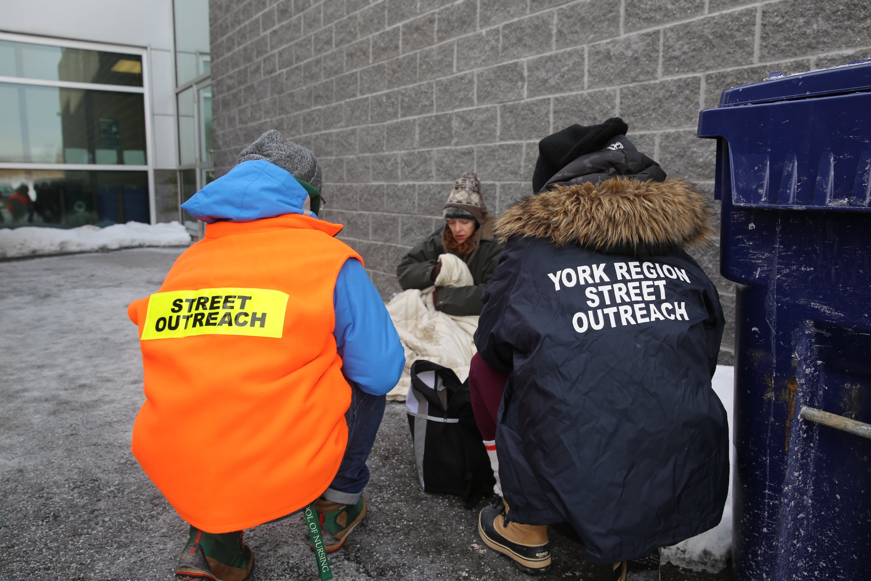 Two people helping a homeless person