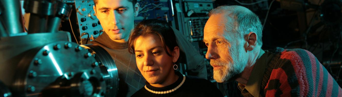 Three researchers working with machinery