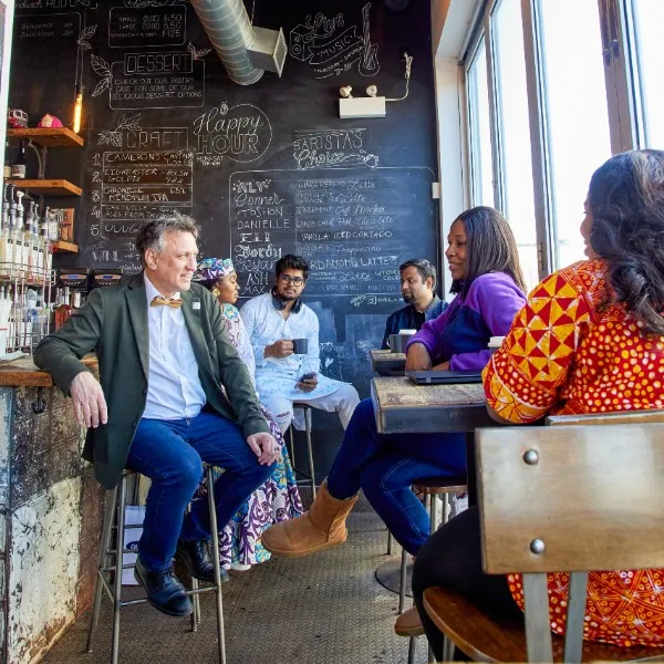 Students in a cafe with a professor