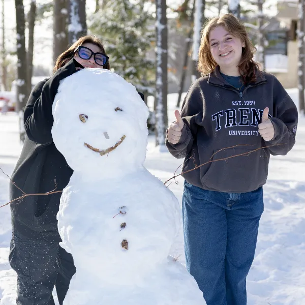 Students building a snowman on campus