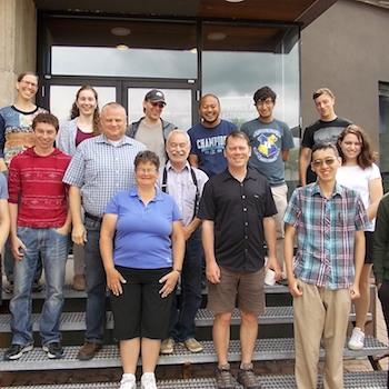 Faculty and student staff for the summer semester in 2017, standing outside in a row in front of the science complex