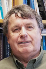 Close up of Peter Dawson in front of bookshelf