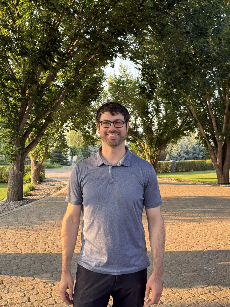 Professor standing among trees on a pathway