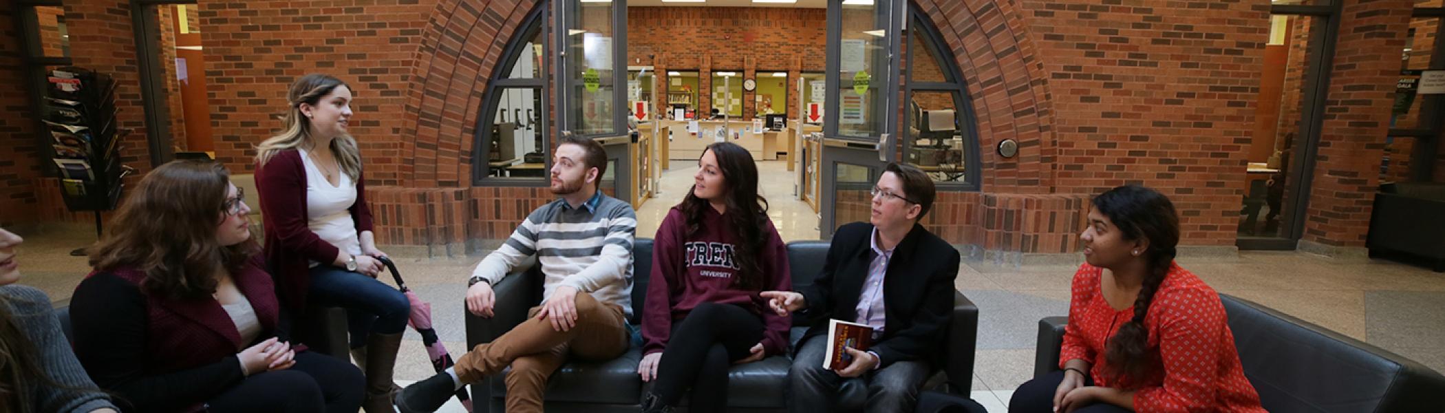 Student and teachers sitting in the common area Trent University Durham chatting 