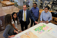 Dr. Franklin discussing Trent's lands plan with students in the library