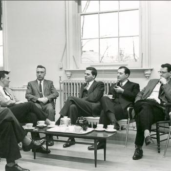 THB Symons sitting in a room with colleagues.