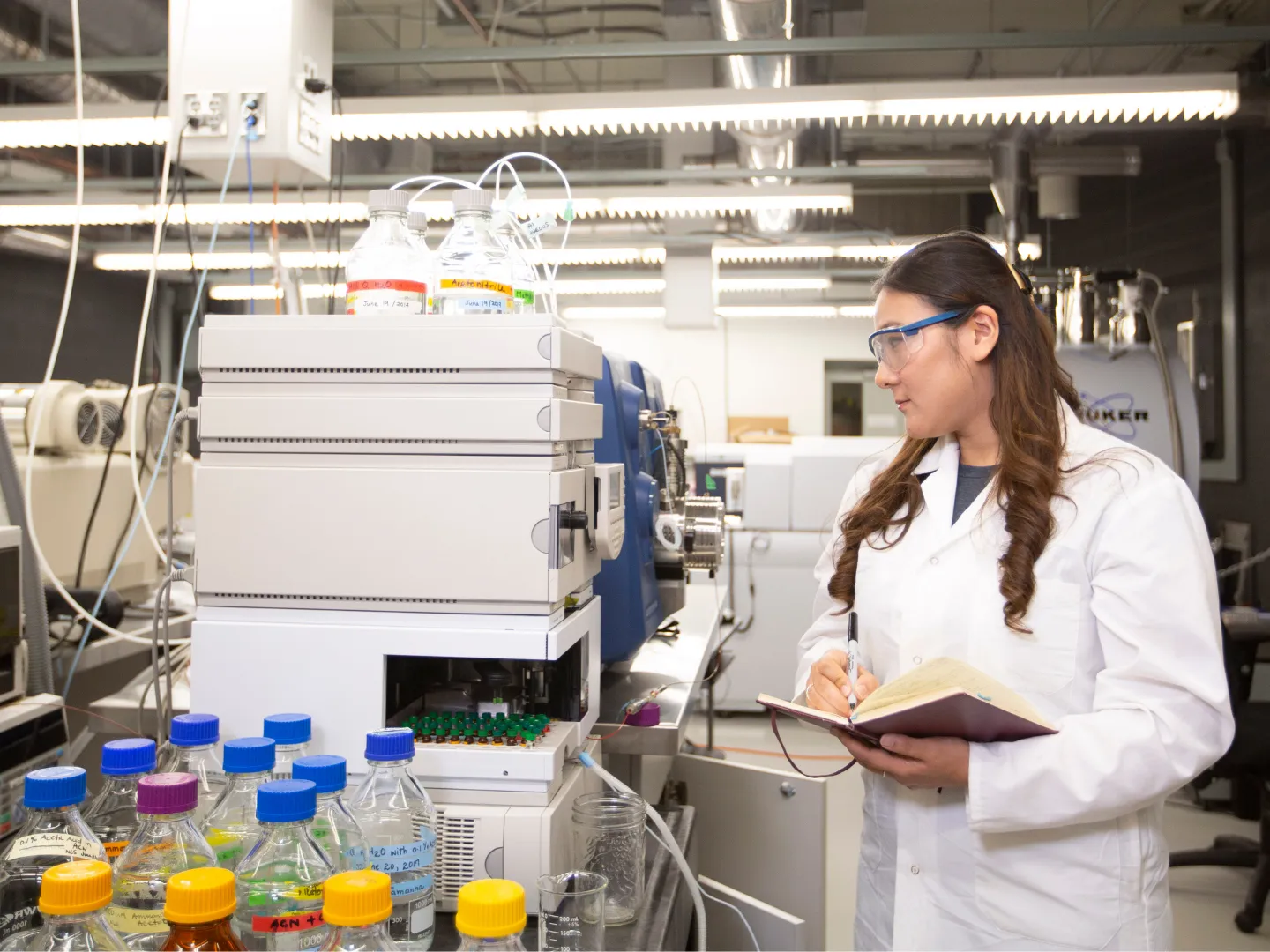 Student in lab, looking at equipment.