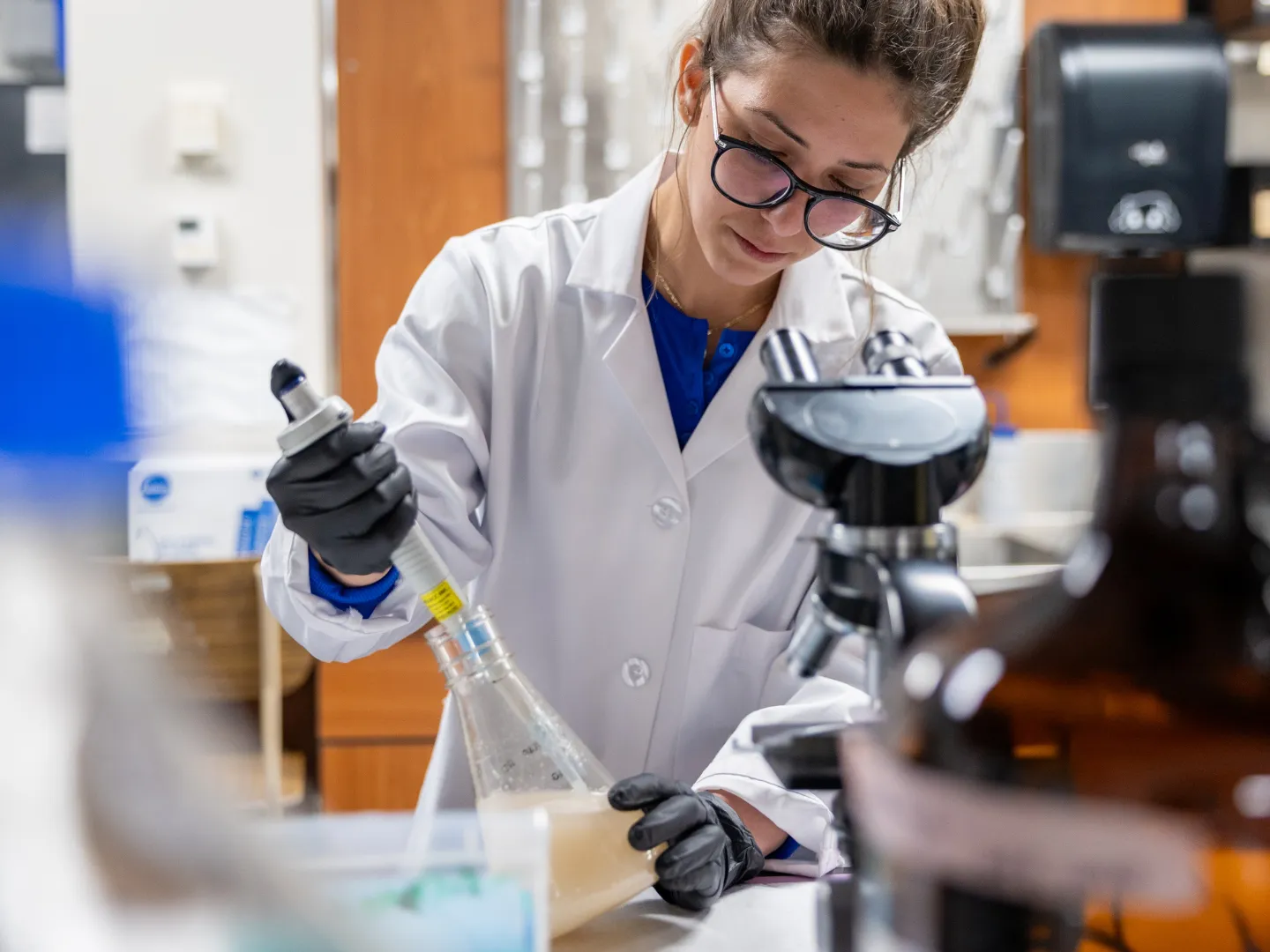Student in lab using pipette.