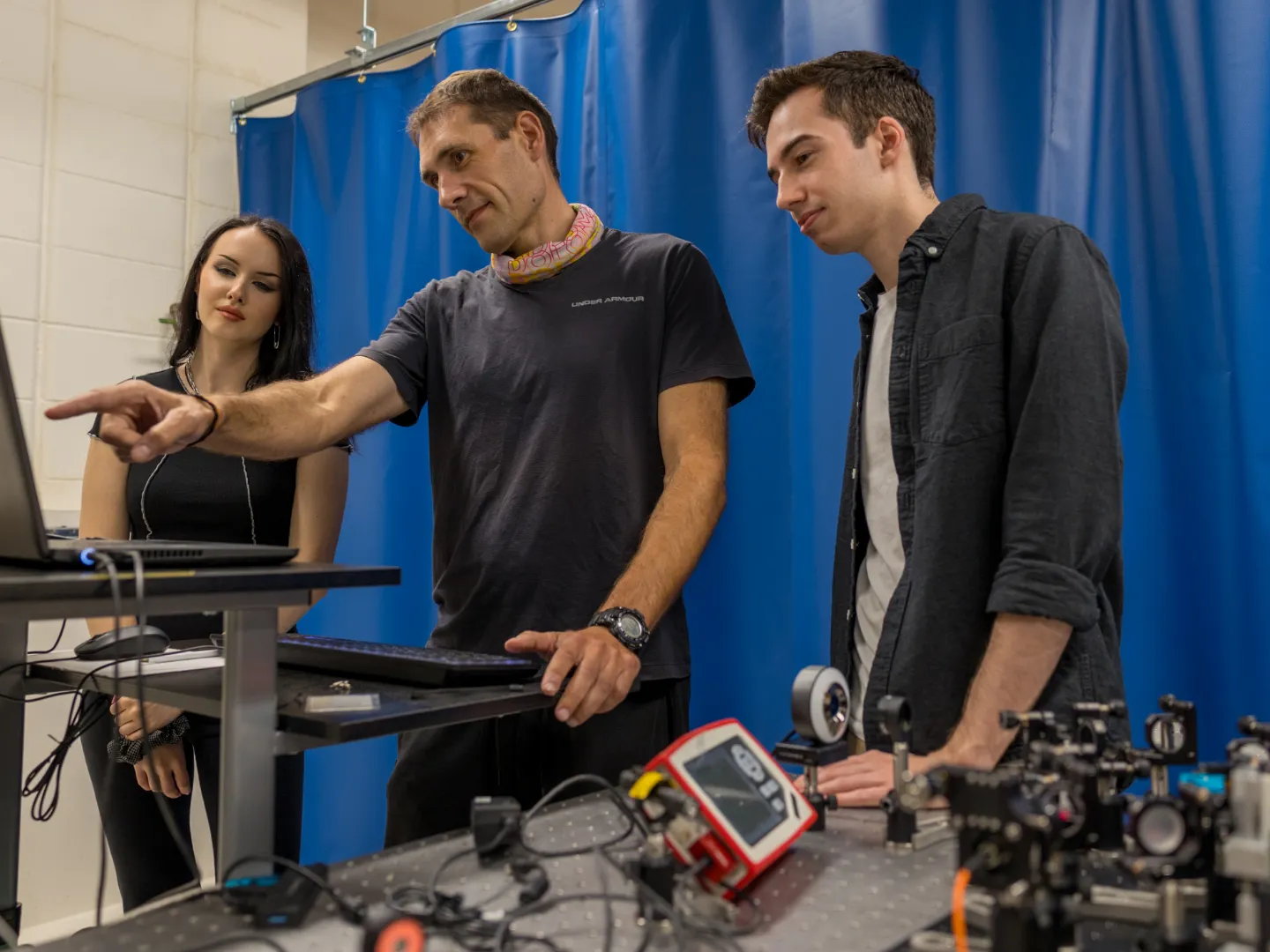 Professor showing students research on computer.