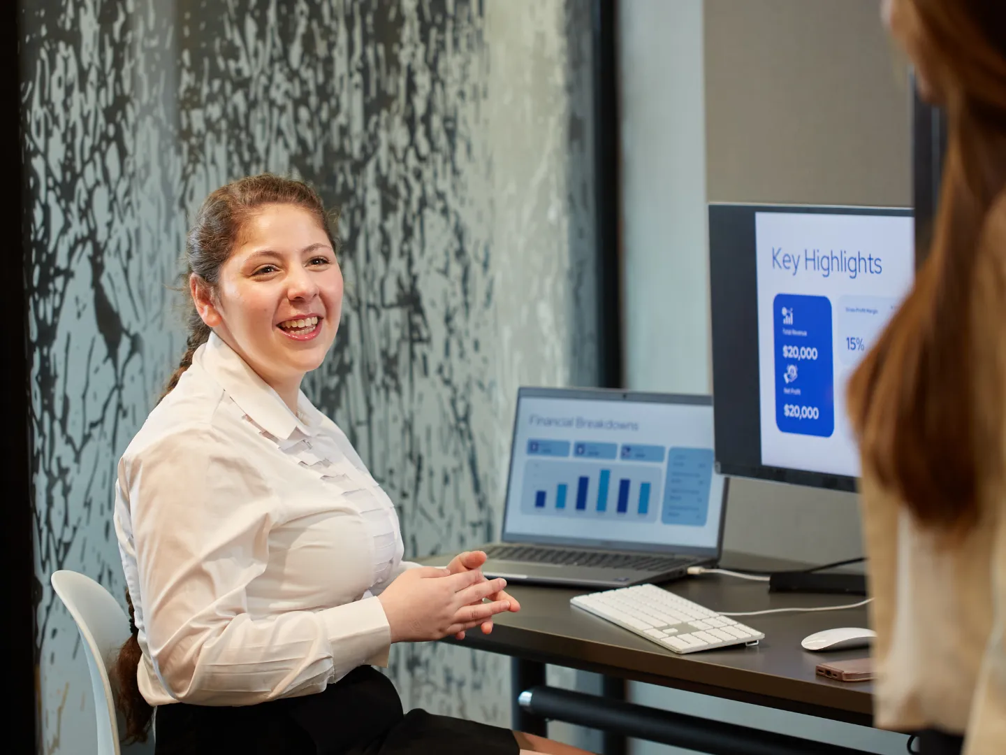 Student at desk with economics numbers on the screen.