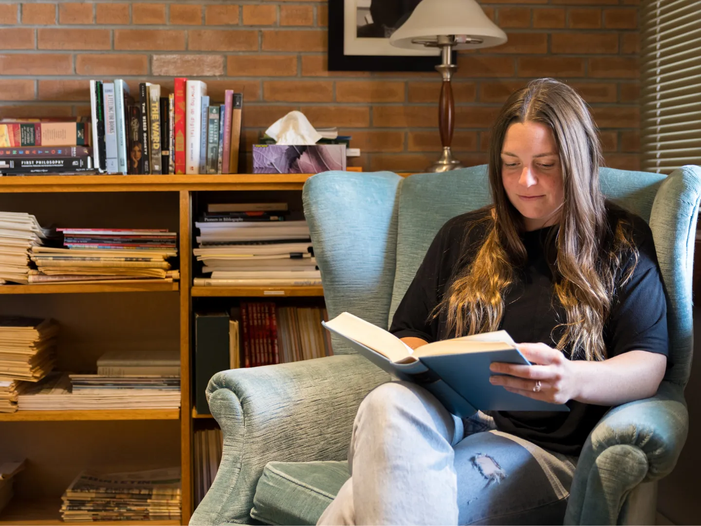 Student reading a book at Traill College.