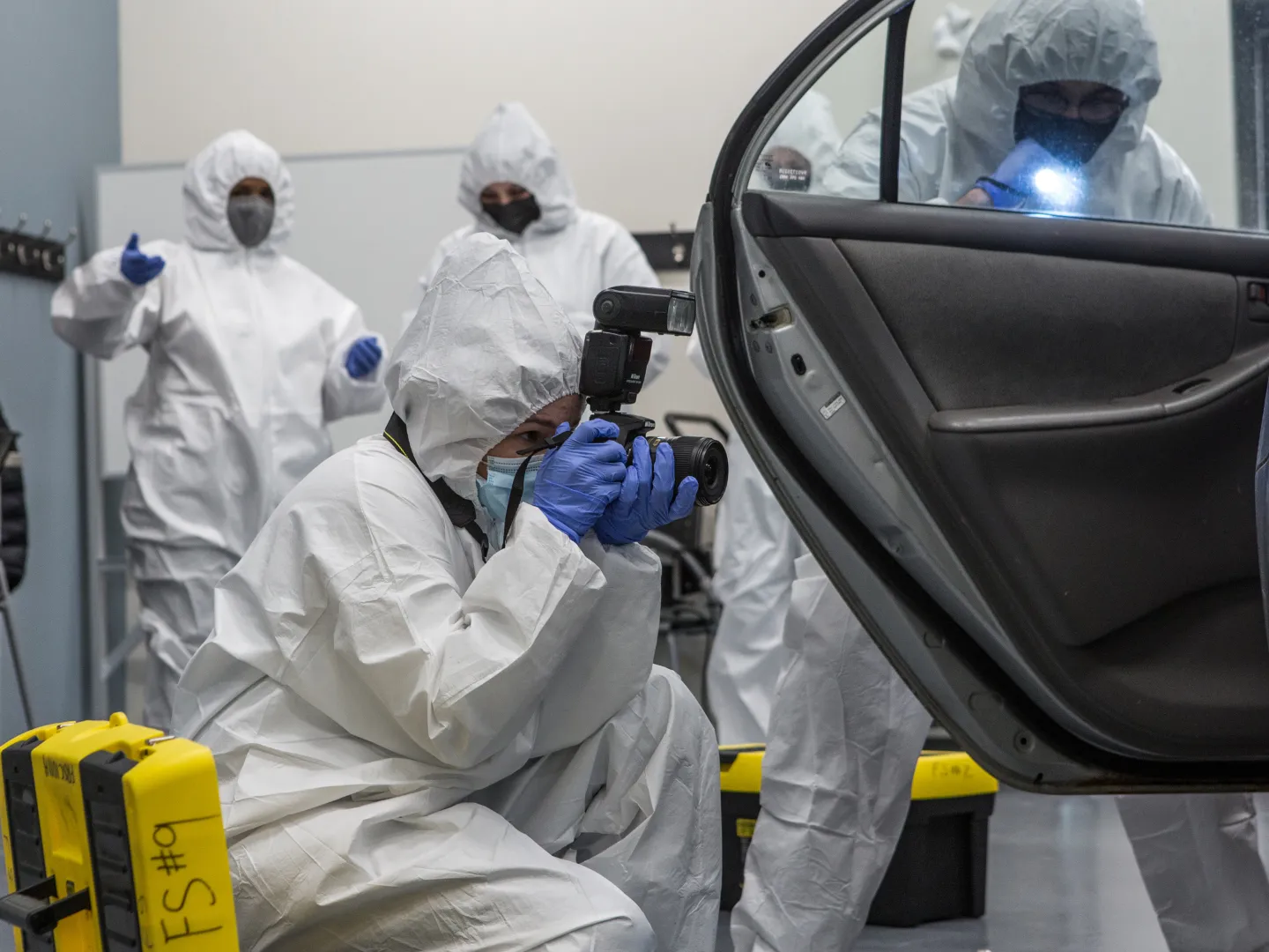 Forensics science crime scene, student taking photos of evidence in car.