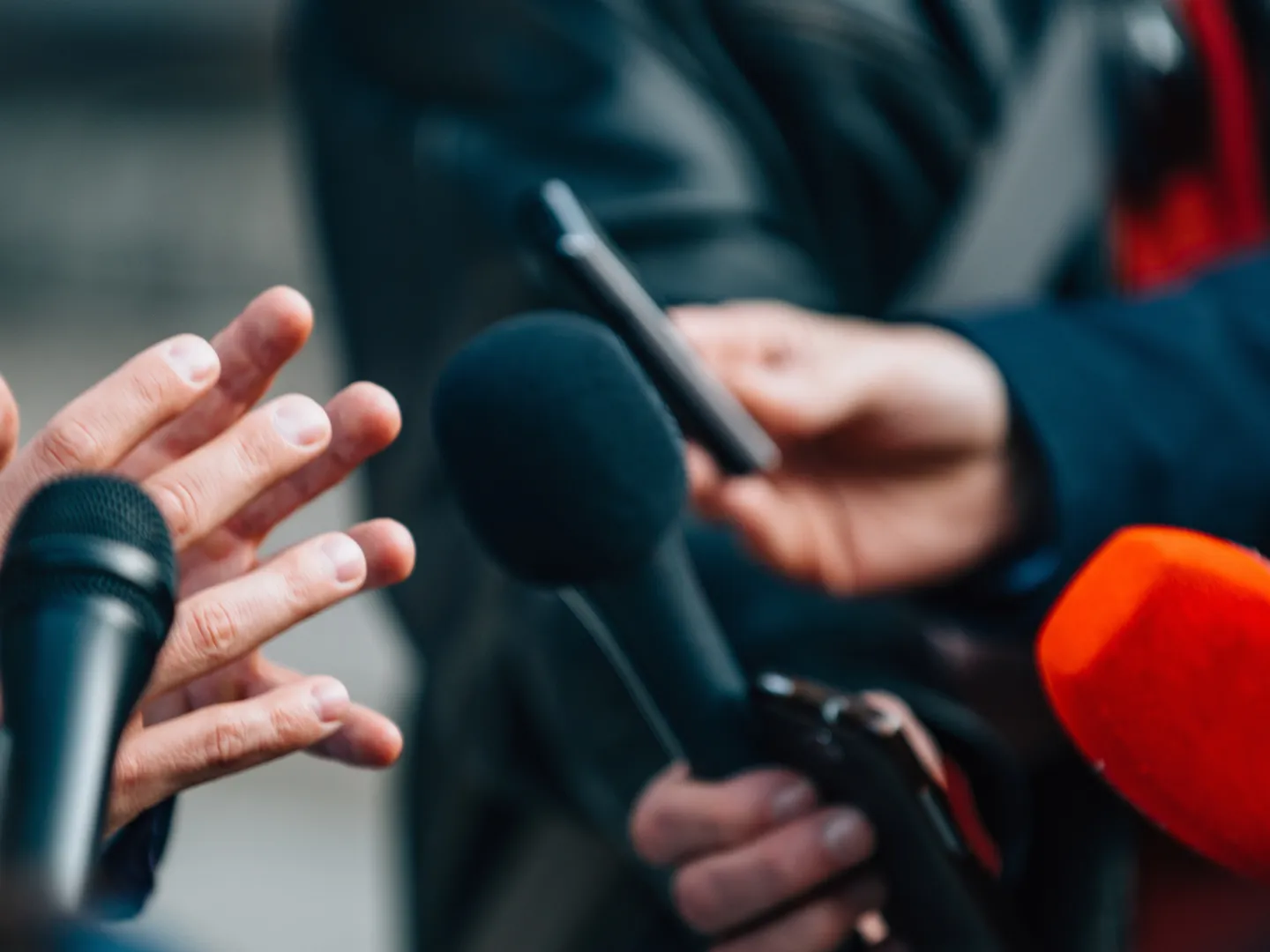 Person being interviewed by reporters.