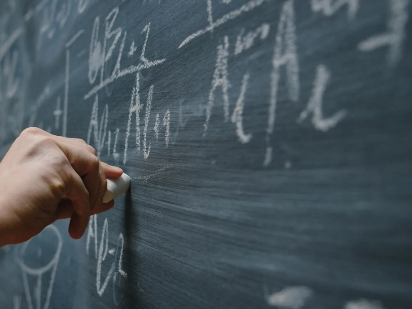 Math being written on chalk board.