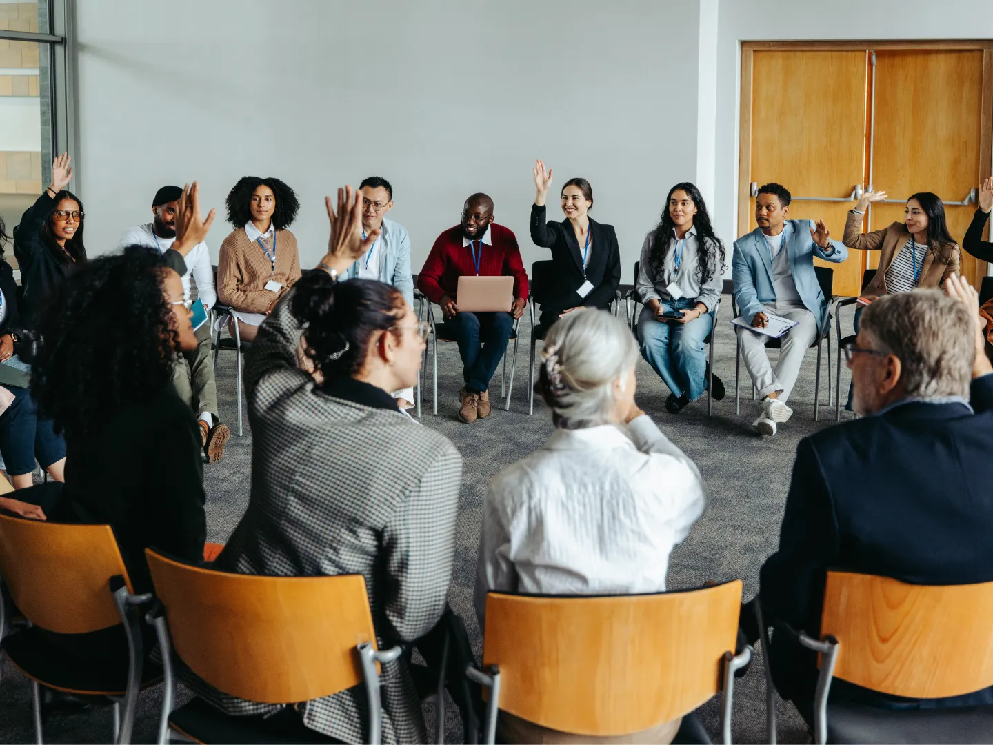 Group talking in circle with some raising their hands.
