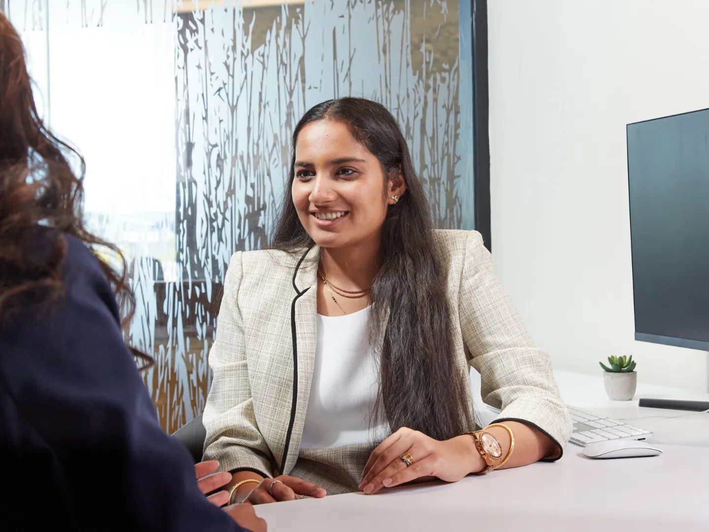 Student talking to another student in office.