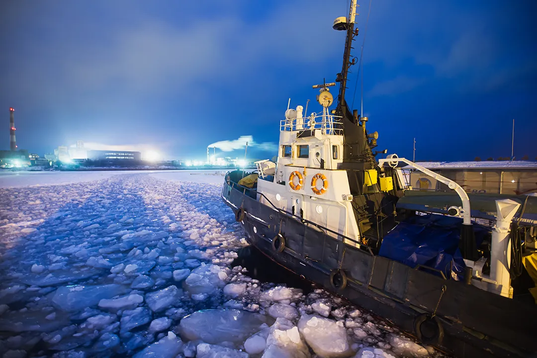 Boat travelling through ice towards town