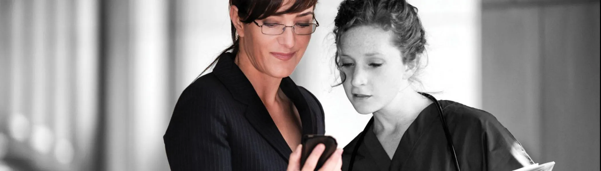 A nursing professor and student examine vitals on a device