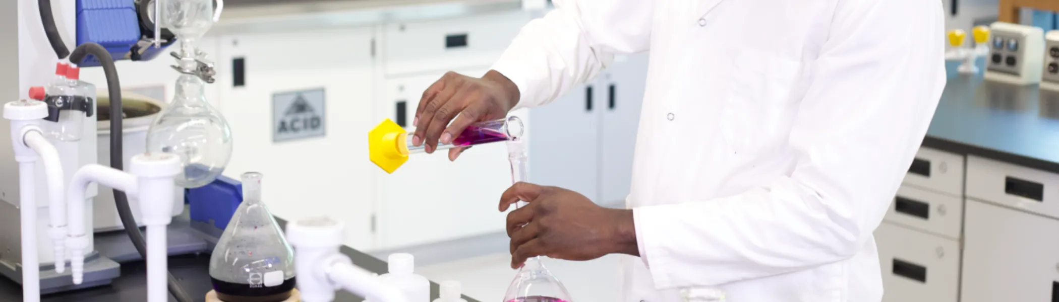 Trent University student in lab handling chemicals.  