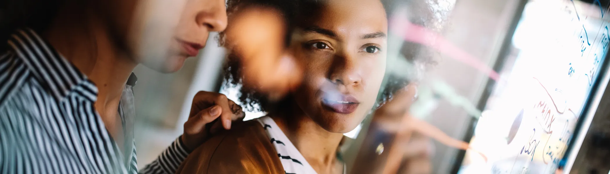 Two people looking at a board.
