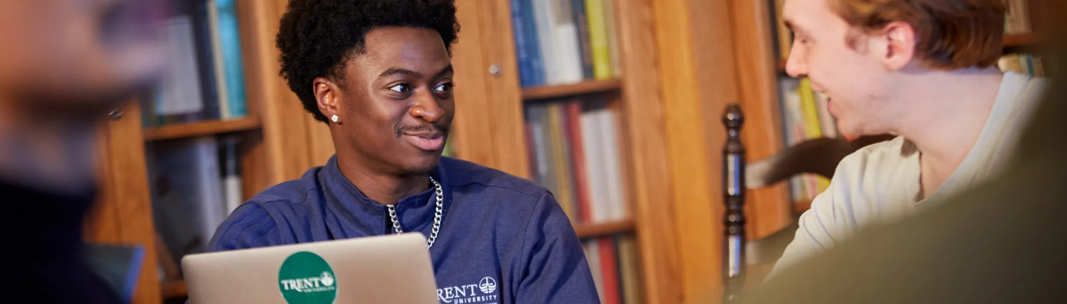 Trent University students working together on a computer.
