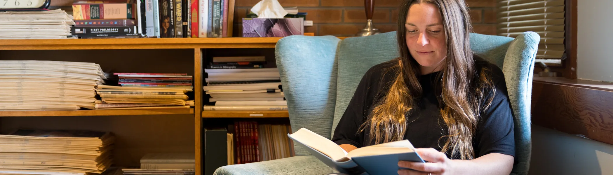 Trent University student reading a book in Traill College.