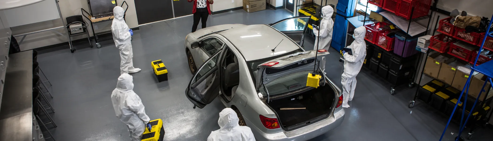 Trent University Forensics science students and professor in garage lab car.