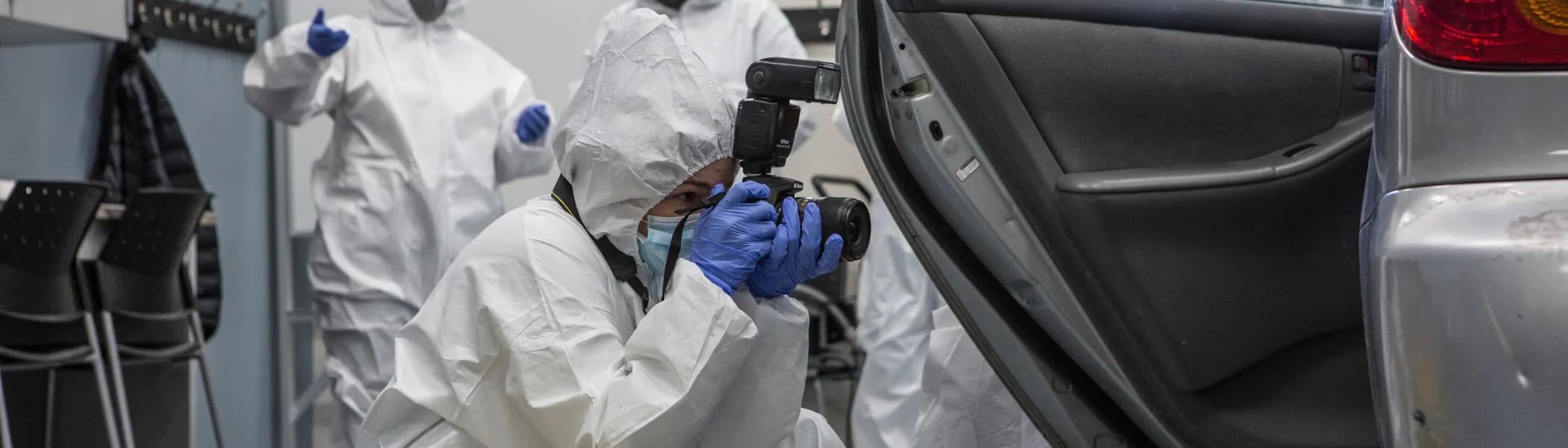 Trent University Forensics science students in lab, taking photo of a car.