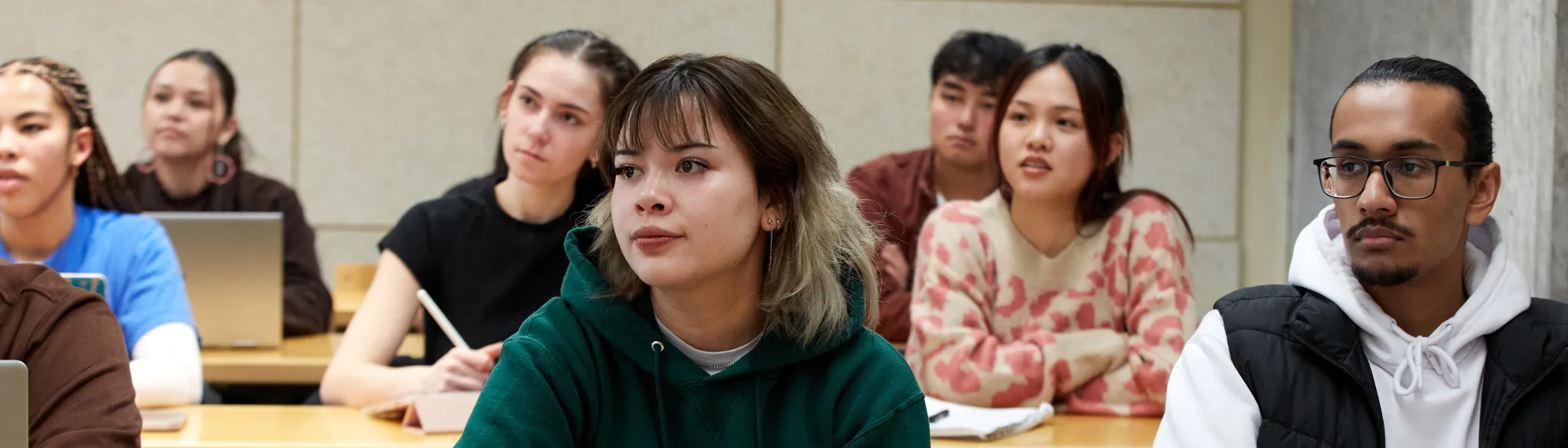Trent University students, in lecture, listening to professor.