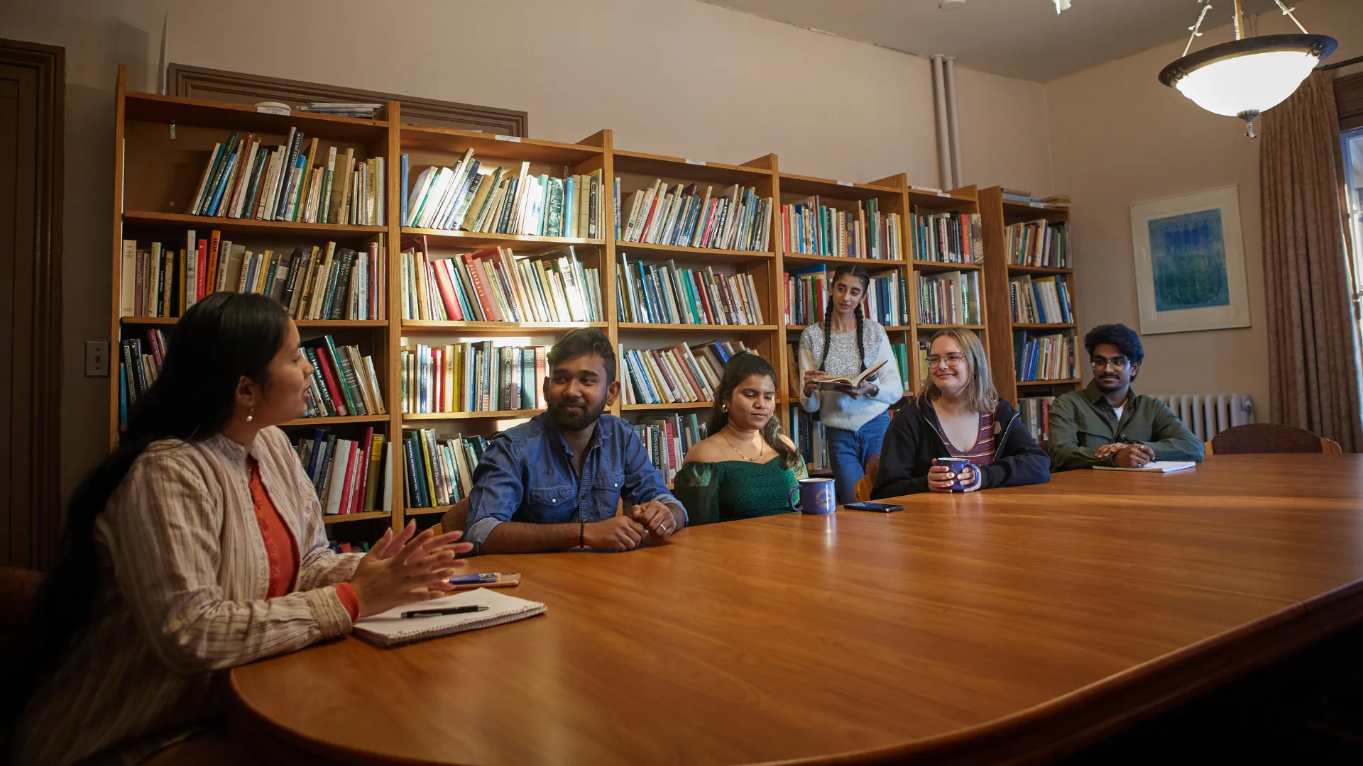 A group of Trent University students, talking in Kerr House classroom.