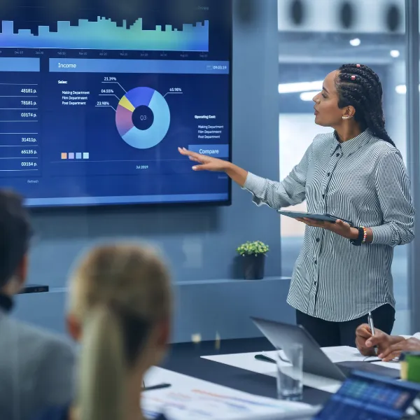 In business meetings, a person uses a TV Screen with Big Data, Statistics to talk about the company.