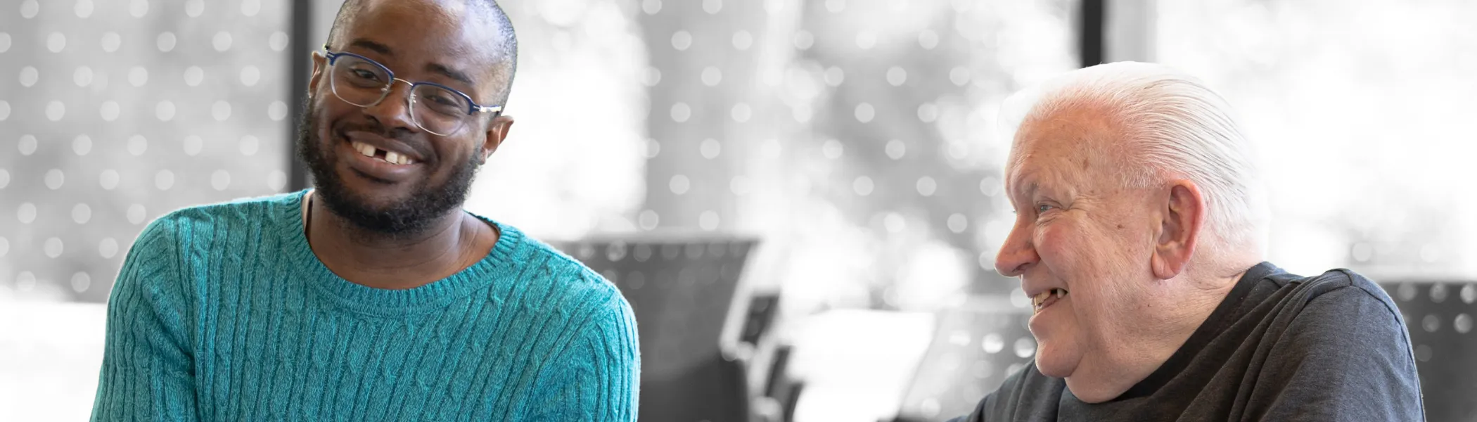 A student and a senior laughing with each other. 