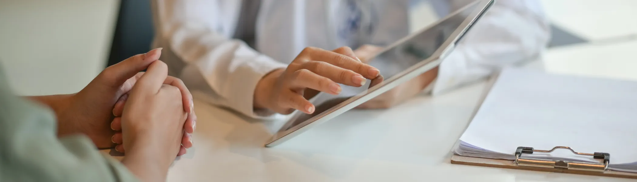 Doctor showing a patient some information on a digital tablet.