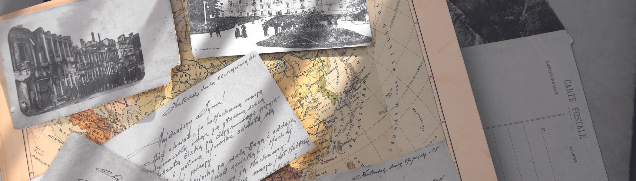 Maps, historical documents and photos, on a desk.