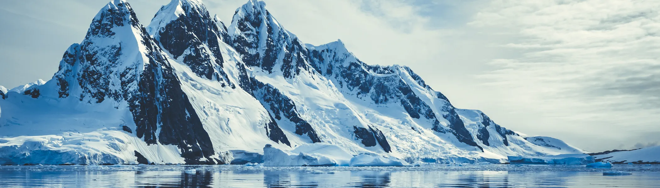 Ice covered mountains in polar ocean.