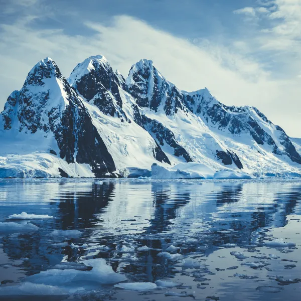 Ice covered mountains in polar ocean.
